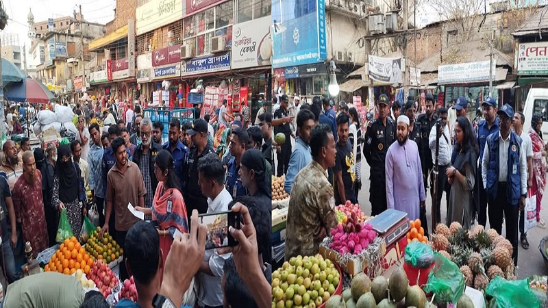 ফরিদপুরের চকবাজারে র‍্যাব সদস্য ও ম্যাজিস্ট্রেট বাজারের বিভিন্ন দোকানে পণ্যের মূল্য তালিকা পরীক্ষা করছেন এবং ব্যবসায়ীদের সাথে কথা বলছেন।