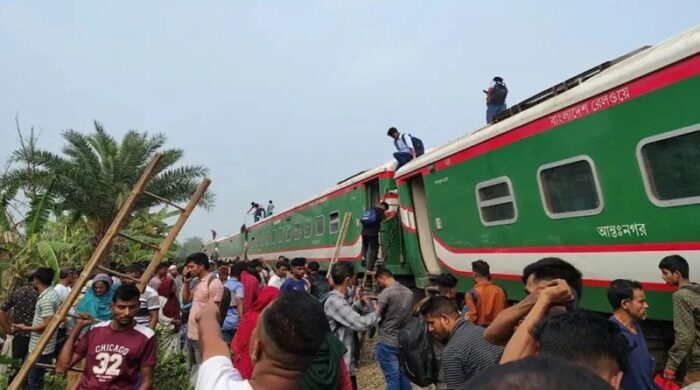 বগুড়ার সান্তাহারে তিলকপুর স্টেশনের কাছে নীলসাগর এক্সপ্রেসের লাইনচ্যুত হয়ে পড়ে থাকা বগিগুলো ও পাশে উৎসুক মানুষের ভিড়।